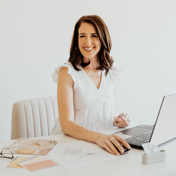 Sarah Pence, sitting at a desk working on her laptop and smiling.