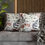 Thumbnail: White pillow cover with illustrated leaves and berries in sage green, rust, charcoal grey, and soft blush, arranged in a mode