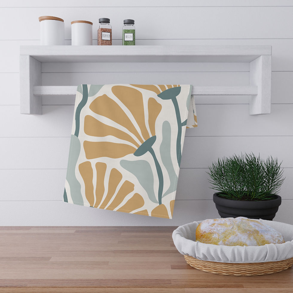 Tea towel featuring a modern ginkgo leaf pattern in mustard, sage green, and cream, hanging in a stylish kitchen.