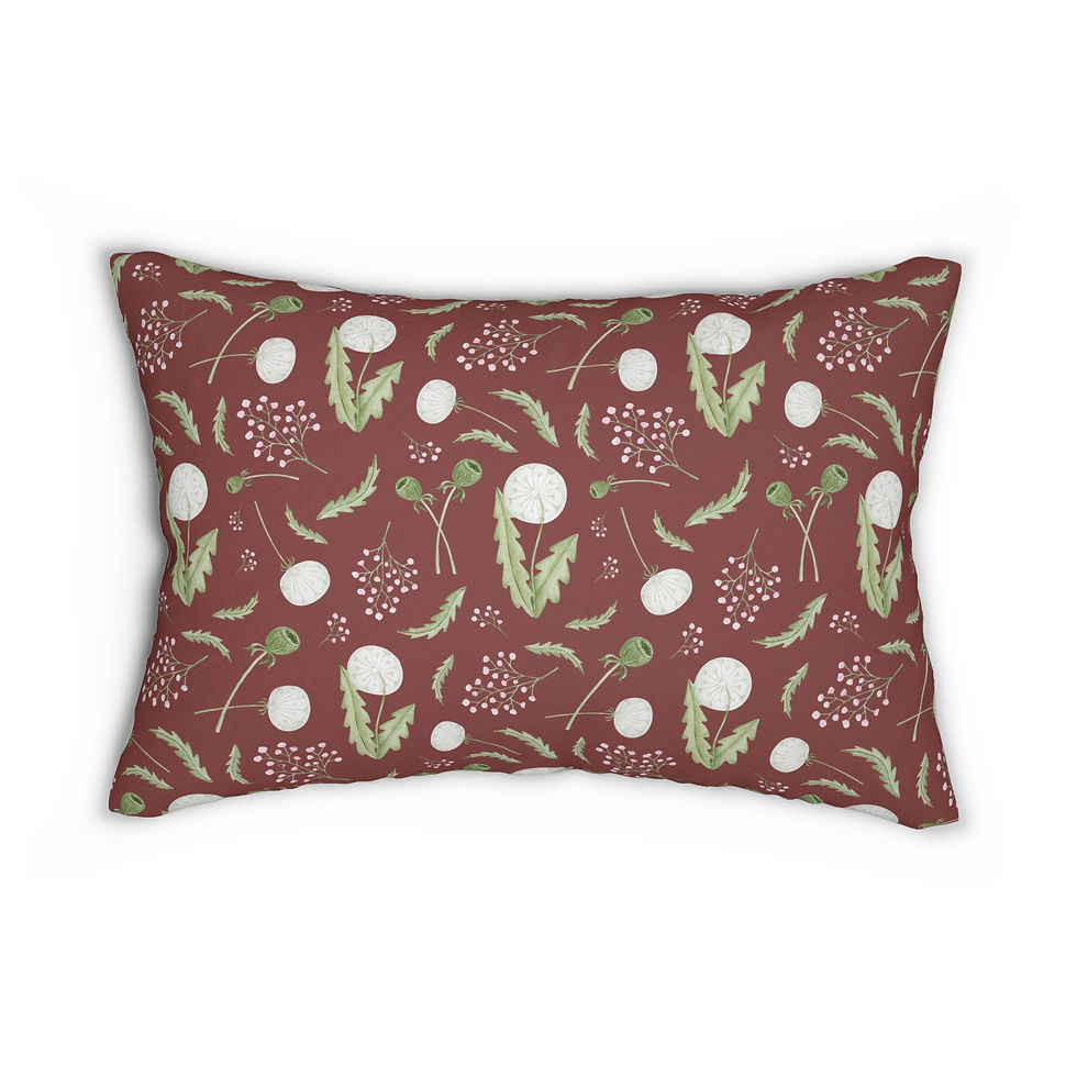 Holiday lumbar cushion with white dandelions, green leaves, and berry sprigs on a warm red background in a botanical design