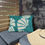 Thumbnail: Outdoor pillow with bold teal and cream abstract floral design, adding vibrant tropical energy to patio or garden spaces.