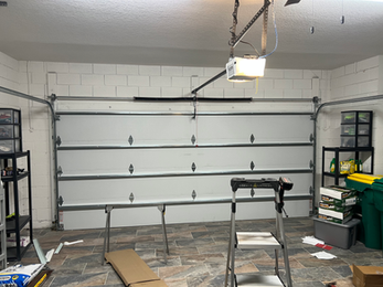 Interior garage door installation showing sectional door panels and hardware