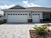 Residential home with white garage doors and a paved driveway