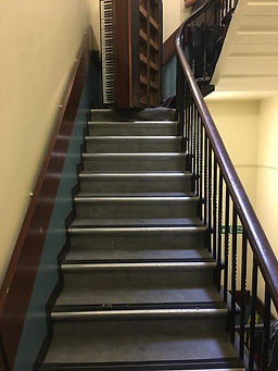 Piano removal in London on a flight of stairs