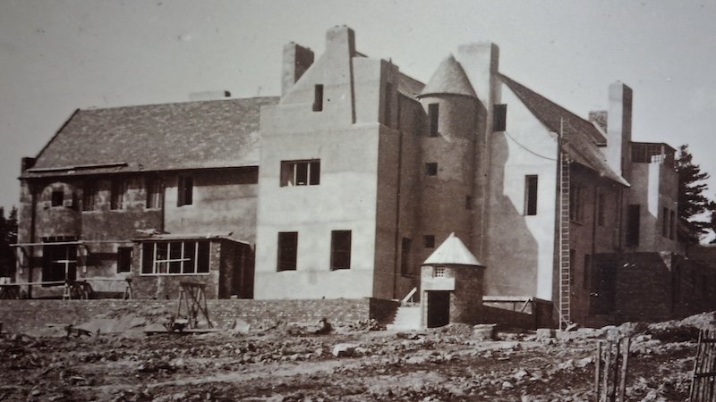 A black and white photograph taken around 1902-3 of The Hill House in Helensburgh under construction. The building is near completion with some of the render applied to the sections on the right hand side of the photograph.