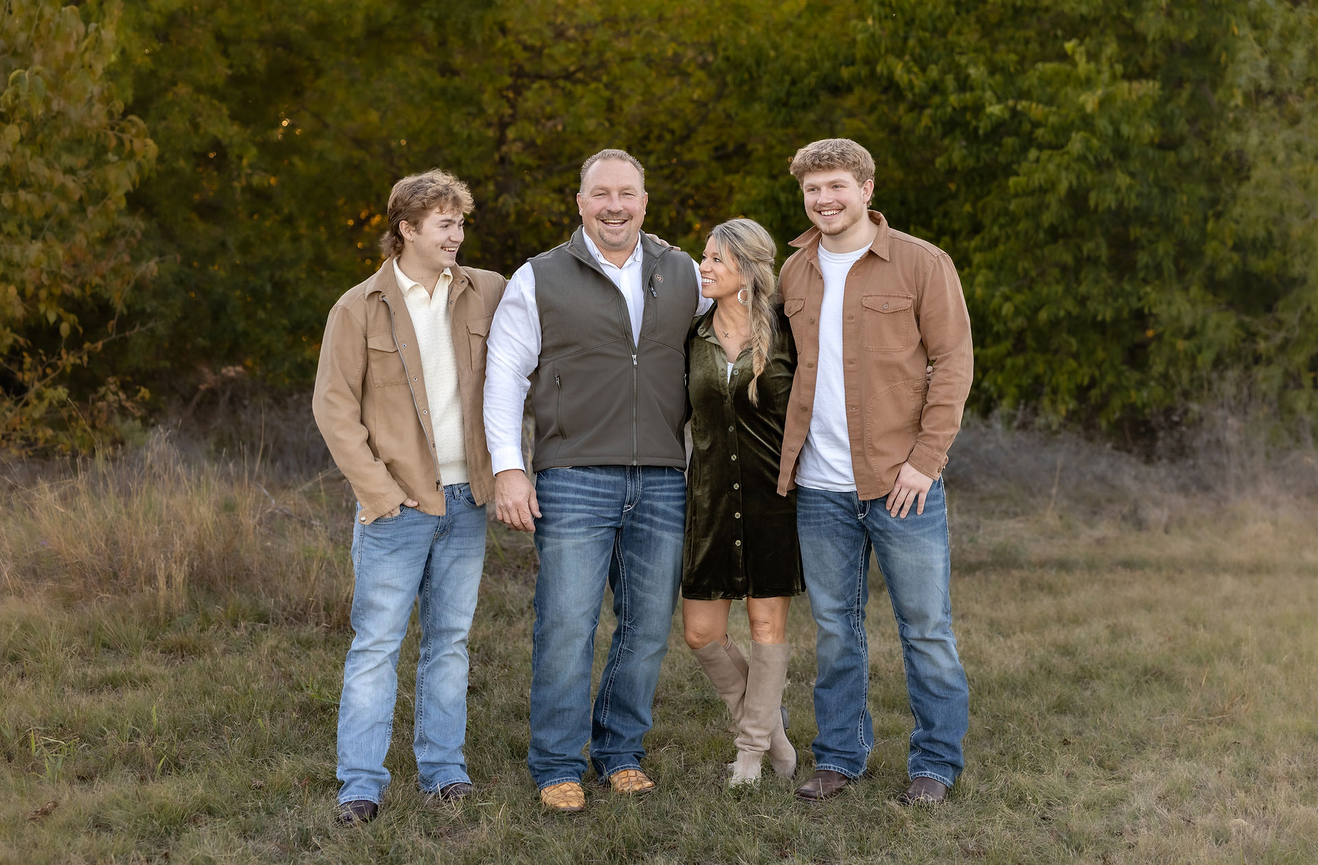 Fall field minis of family standing in golden back lit field 