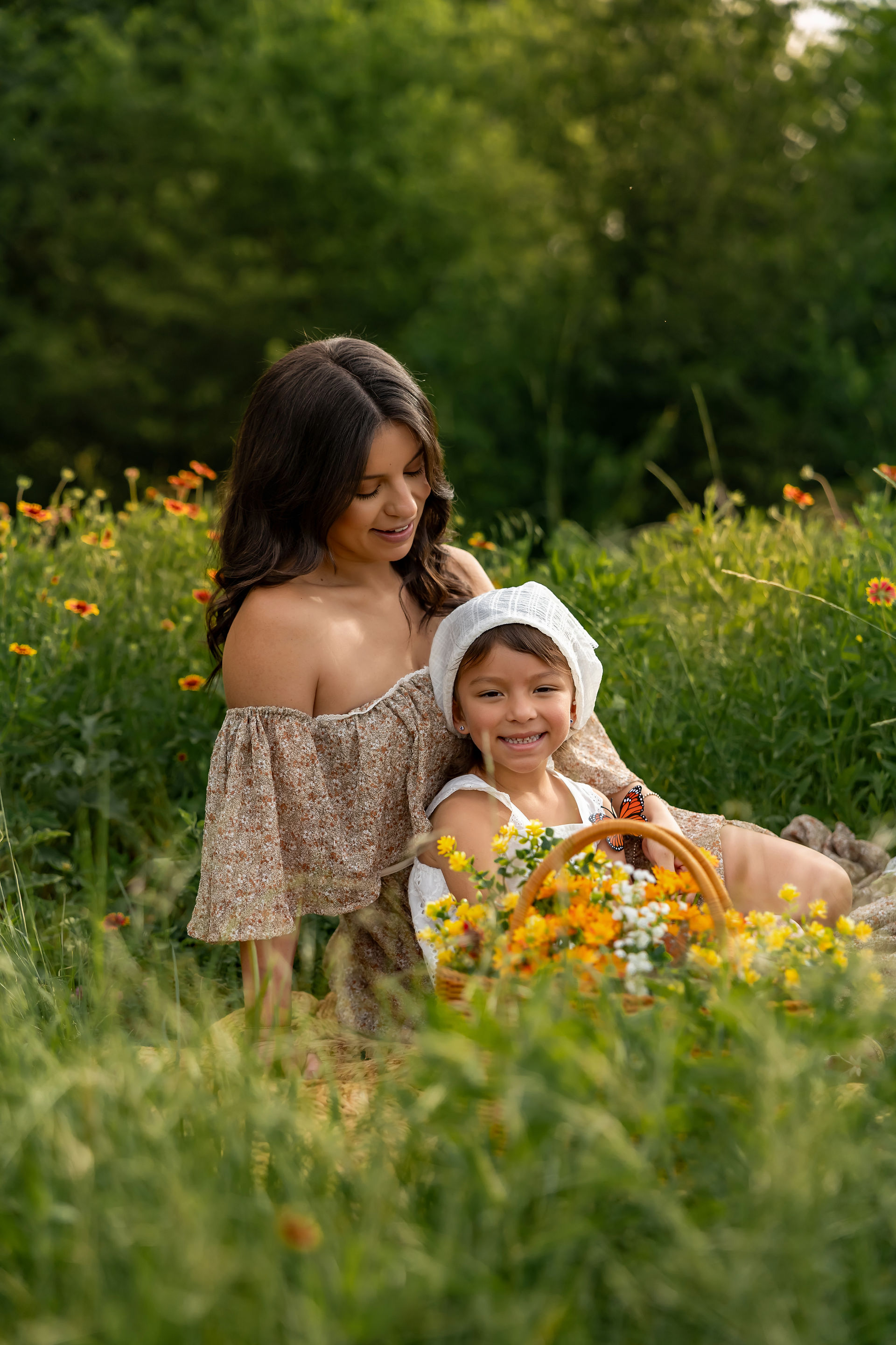 Mother kissing her little girl in a dreamy wildflower field during outdoor family photography session in DFW Texas