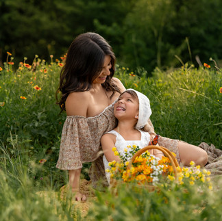 Outdoor Mommy and Me wildflower mini session in DFW featuring floral basket, spring blooms, and golden sunlight