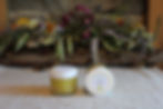 Zwei Döschen Lemongras-Creme vor Blumenarrangement