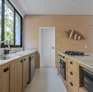 Bancada de quartzito na cozinha, com acabamento claro e resistente, aplicada na área de preparo e cocção, combinando estética natural e desempenho técnico.