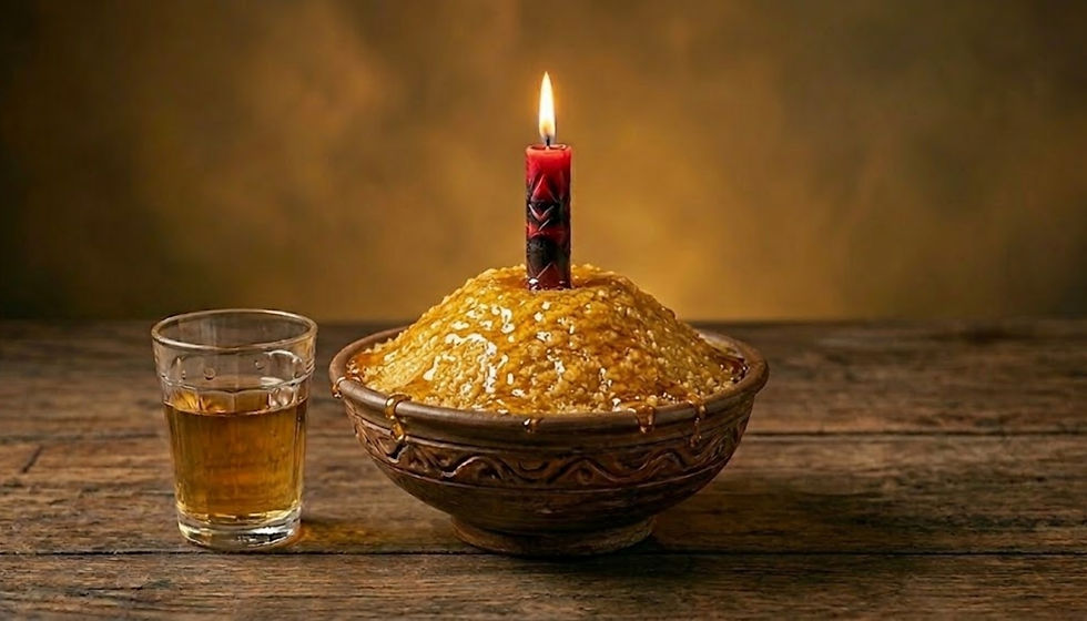 Sobremesa dourada em tigela com vela acesa, ao lado de copo com bebida âmbar sobre mesa de madeira, clima festivo.