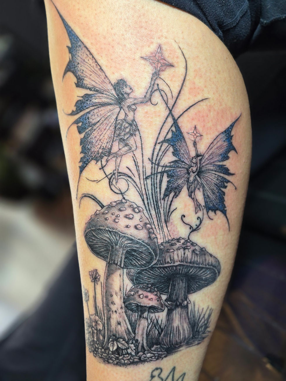 Detailed black and grey fairy and mushroom fantasy tattoo on a thigh, fine-line and dotwork by Black Brew Tattoo