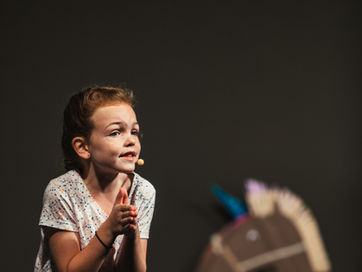 Young girl on stage, performing.