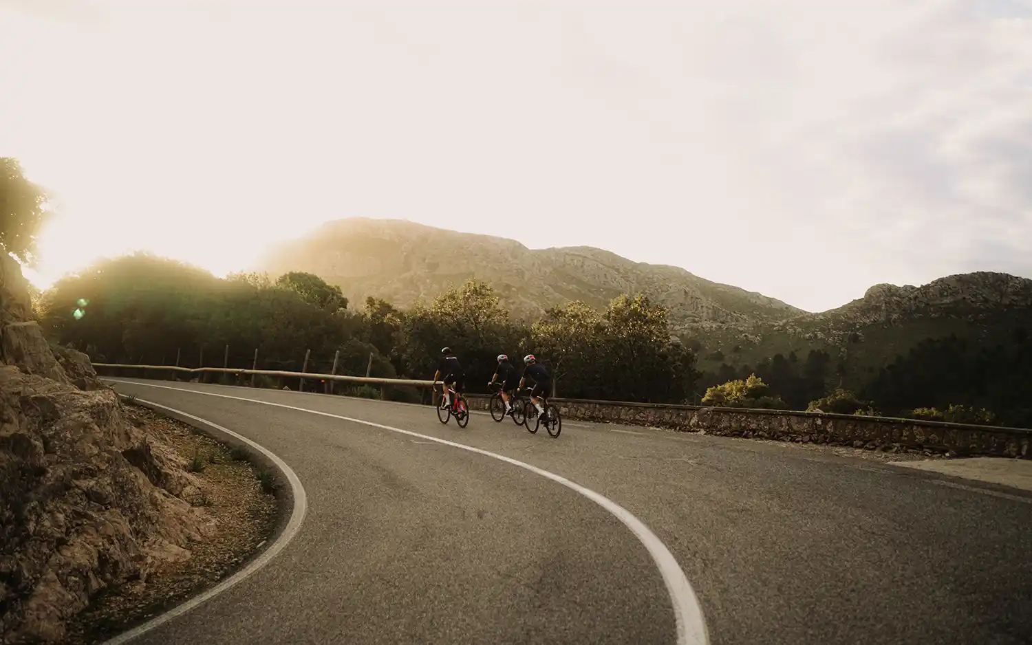 Drei Rennradfahrer in malerischer Landschaft auf Mallorca
