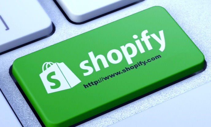 An image showing a computer screen with the Shopify login page displayed, featuring fields for entering email and password, along with a login button."