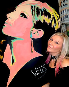 Artist Stacey Wells posing with her pop art painting of Barbra Streisand.