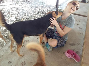 volunteer being licked by Doris one of our resident dogs.