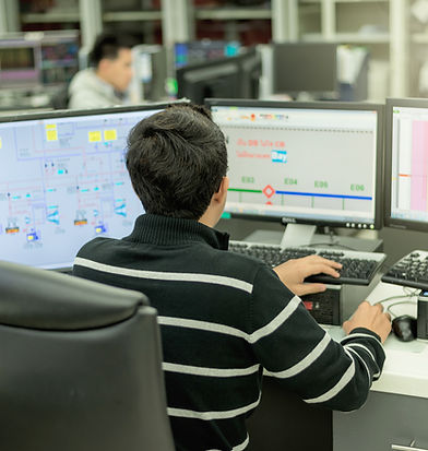 image of a man at a desk monitoring processes shown on a SCADA system