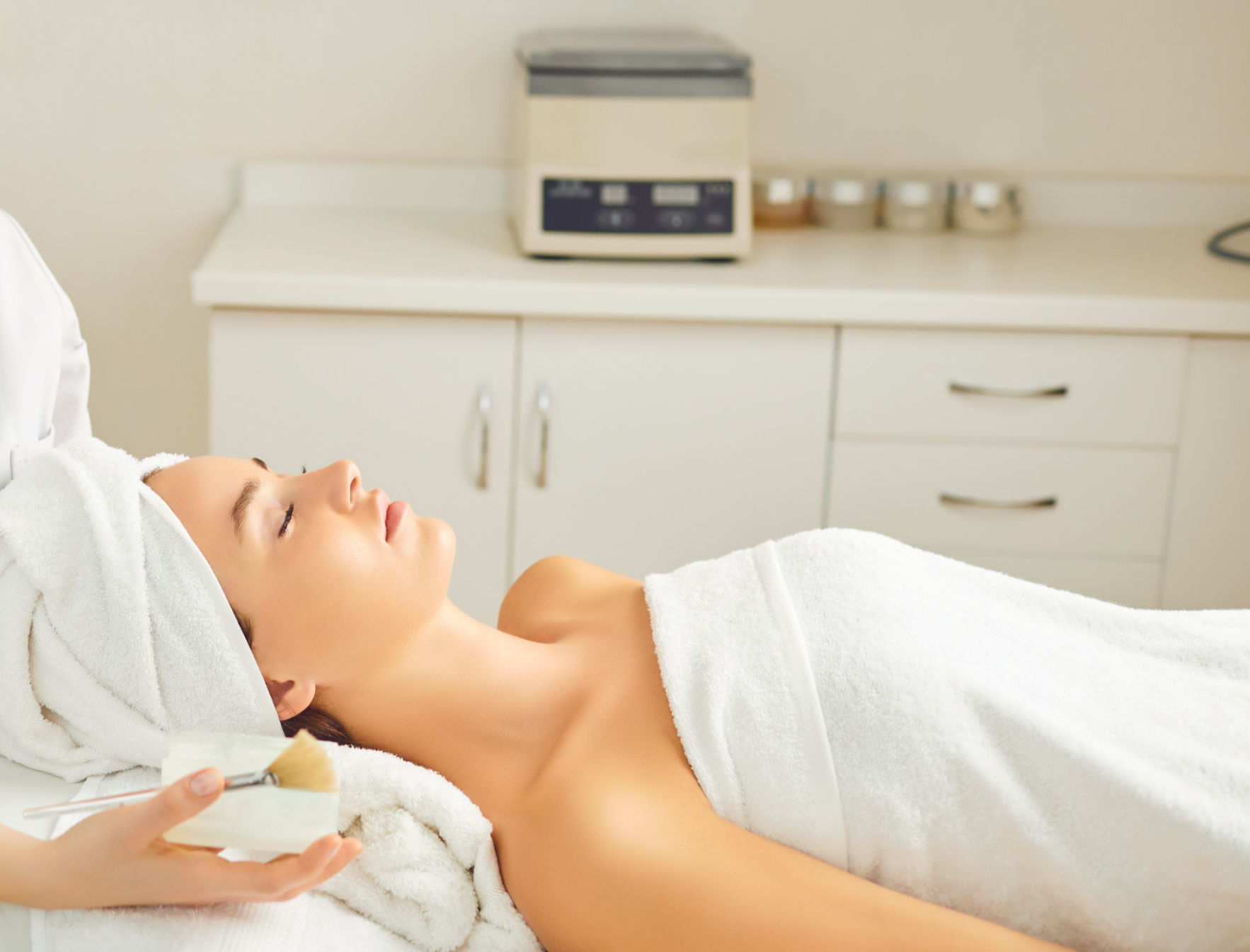 Patient lying on a bed during a microneedling session 