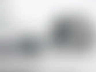 Composición editorial minimalista con un tensiómetro digital (riesgo bajo) en primer plano y un desfibrilador (riesgo alto) en segundo plano, ambos apagados, en un entorno clínico moderno. Representa la diferencia entre modalidades de trámite para comercialización: registro sanitario automático vs registro sanitario, conforme a los procedimientos del Decreto 4725 de 2005 (arts. 21 y 22) y el flujo de radicación y verificación inicial.