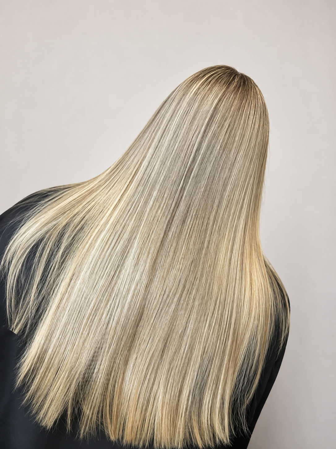 Client receiving a professional wash and blow dry in a salon, with hair cleansed, conditioned, and styled to a smooth, shiny, voluminous finish.