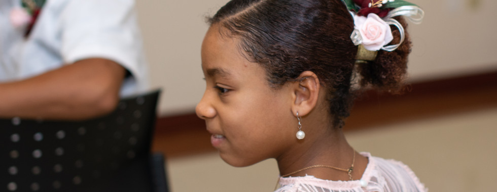 A young daughter of the bride wears a pink dress with flowers in her hair for a courthouse wedding in Austin by the Domain.