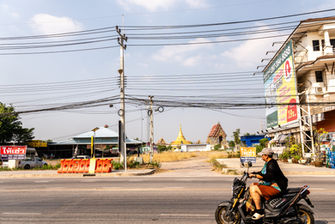 A person riding a motorbike on a road in Thailand