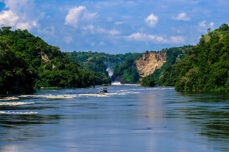 boat-sailing-water-middle-cliffs-with-trees-plants-with-blue-sky (1).jpg