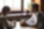 Side view smiling biracial woman sitting at table in cafe with caucasian man couple talkin