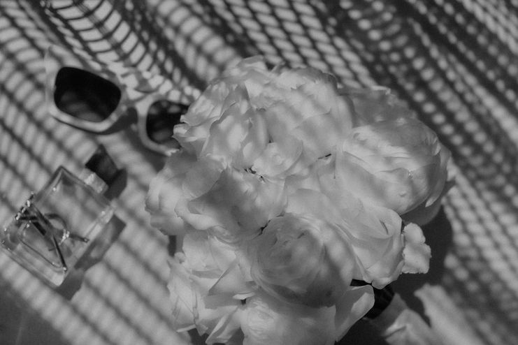 Detailaufnahme eines funkelnden Armbands zwischen floralen Texturen in warmem Licht.