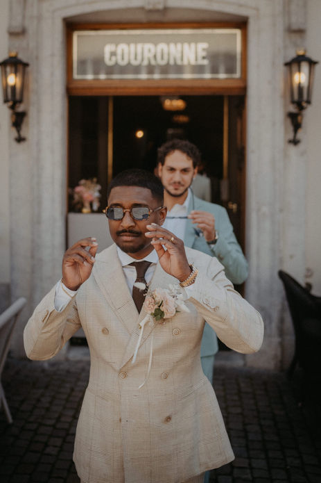 Bräutigam und Trauzeuge feiern lachend vor der Location – energiegeladener Start in den Tag.