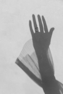Künstlerisches Schattenbild einer Hand mit Verlobungsring – modernes, minimalistisches Hochzeitsdetail.