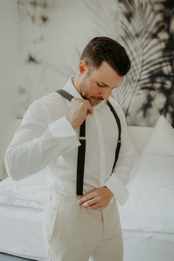 Bräutigam richtet seine Hosenträger – klassisches Getting Ready Portrait.