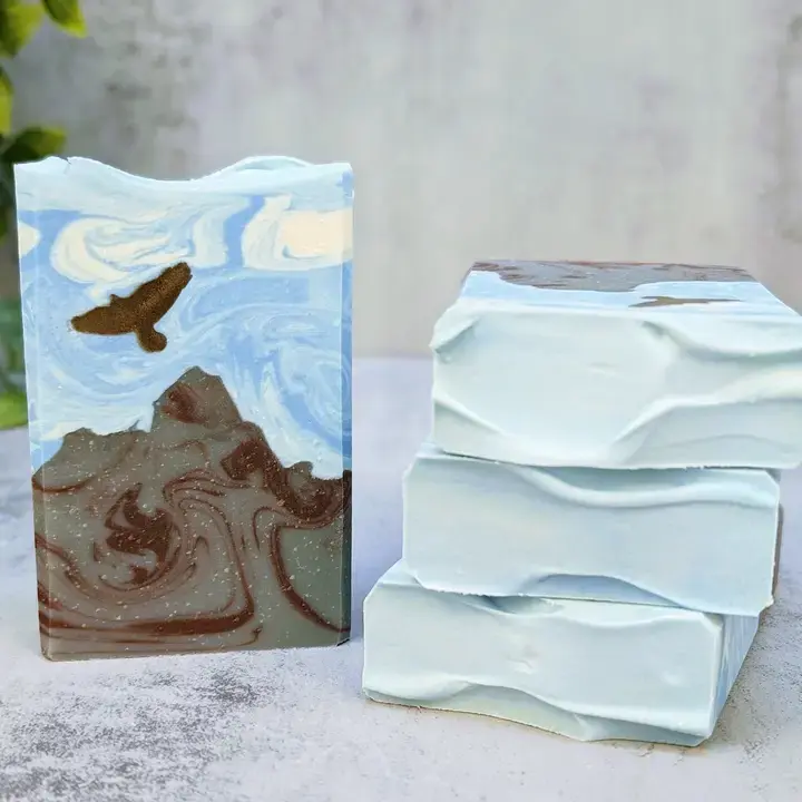 Artisan soap bars, one with mountain and bird design