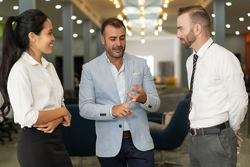 tres-empresarios-positivos-hablando-en-el-vestibulo-de-la-oficina.jpg
