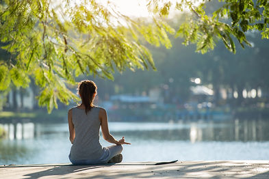 Beautiful woman practicing yoga waterfront in the park._.jpg