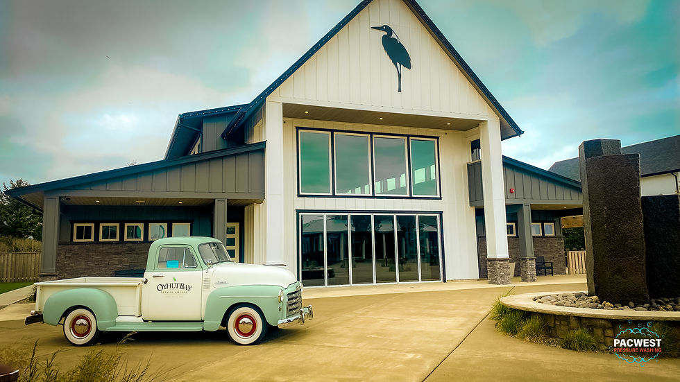 A vintage truck is parked outside the Oyhut Bay community hall, complementing the building's modern design with its classic charm.