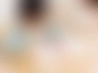 Child drawing numbers with a pencil in a workbook at a wooden table, concentrating. Another child is in the background. Bright, calm setting.