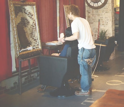 Stylist and customer examining a completed haircut in front of the mirror at Antique Hair Studio