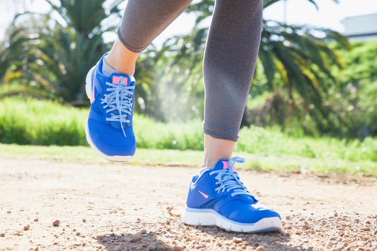 A woman who is jogging on a country path