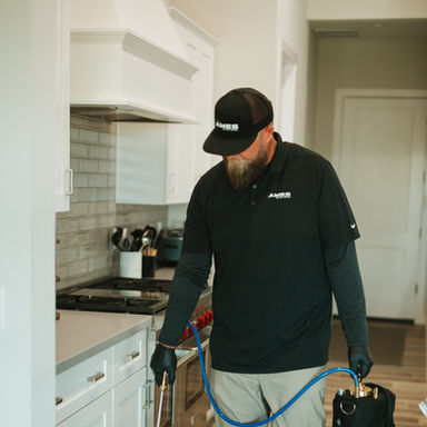 Technician applying weed control treatment indoors.