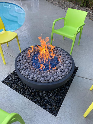 LUXOASIS custom round gas fire pit with river rock on concrete pool deck in the Coachella Valley