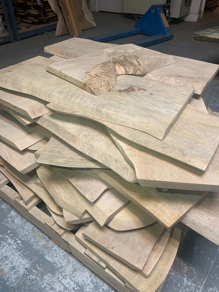Pile of light-colored wood slabs, ready for crafting Diamond Tropical Hardwoods