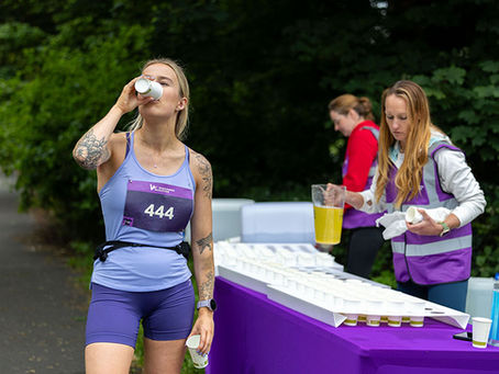 Runner taking a drink of water at a feedstation