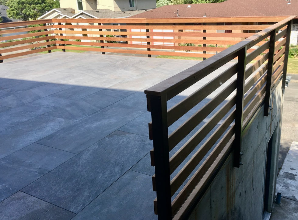 Porcelain paver deck with horizontal Cumaru railing over garage roof