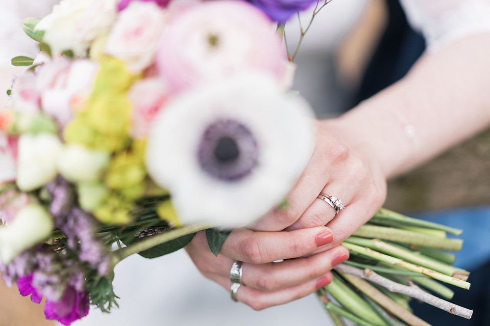 Wedding rings photograph with bridal bouquet in the foreground. Fun wedding photography at Dodford Manor, Northamptonshire. Covering wedding photography in Rutland, Staffordshire, Derbyshire, Lincolnshire, Darley and Underwood Photography.