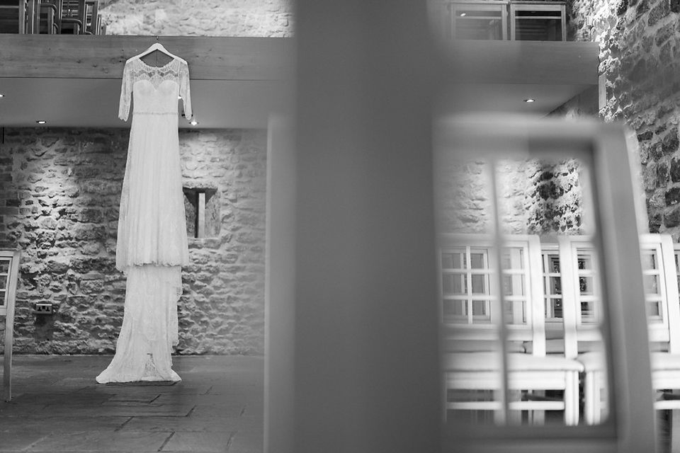 Bride's wedding dress in black and white hanging from balcony at Dodford Manor, Northamptonshire.