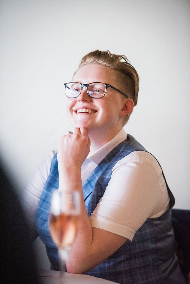 Bride laughing at wedding speeches. Fun wedding photography at Dodford Manor, Northamptonshire. Candid wedding photography. Leicester wedding photography. Covering wedding photography in Rutland, Staffordshire, Derbyshire, Northamptonshire, Nottinghamshire.