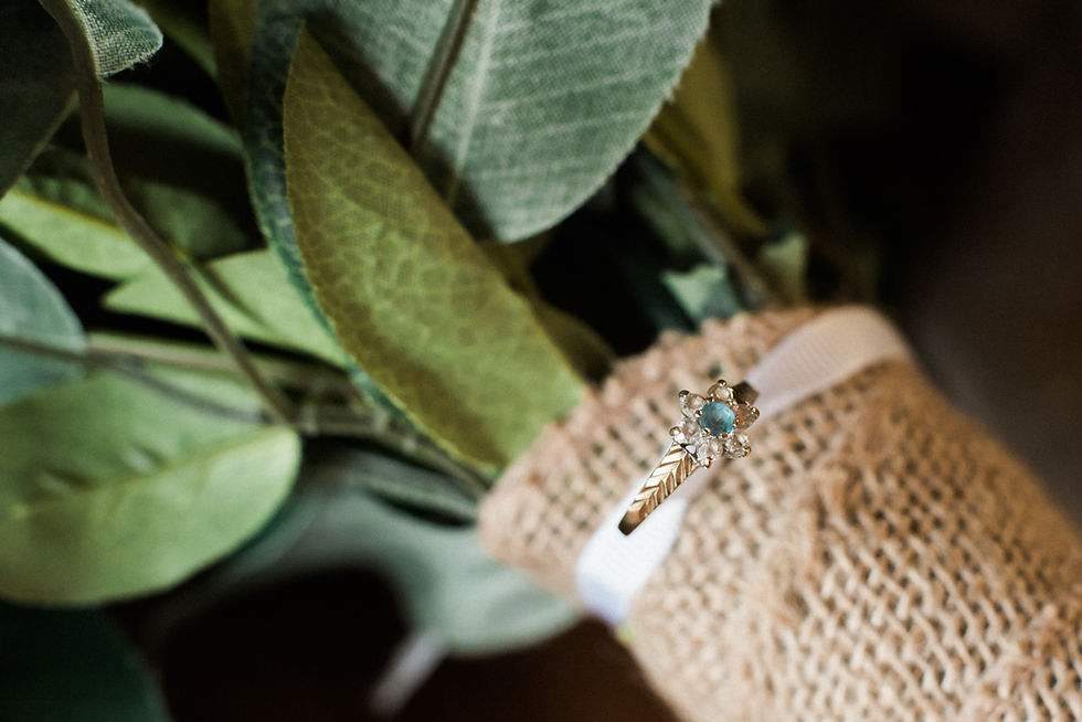 Artificial wedding bouquet with macro focus on a gold and sapphire engagement ring. Hessian boho bridal bouquet. Eco friendly wedding flowers. Wedding photography Leicestershire.