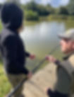 Man teaching fishing with a young person near a lake. A Different Angle.
